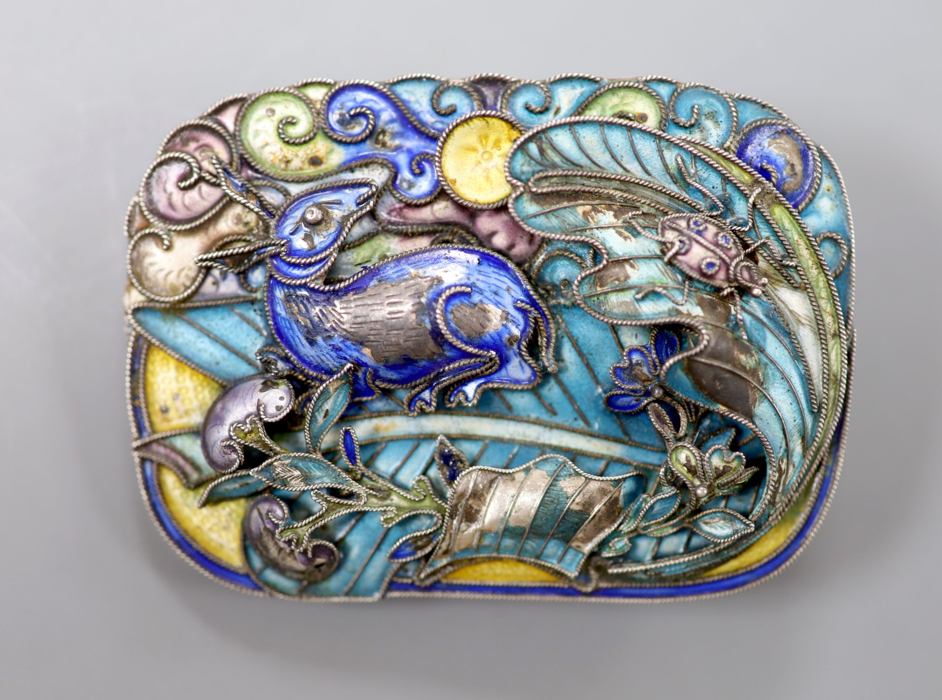 A mid 20th century Chinese? white metal and polychrome enamel brooch, decorated with hare, and ladybird amongst foliage, 58mm, gross 34 grams, (enamel a.f.).
